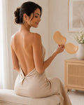 Woman in a backless dress holding the Nuva invisible bra